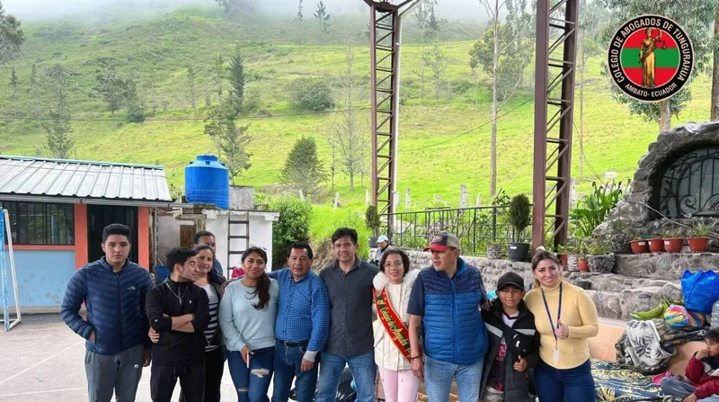 Grupo del Colegio posa en una zona rural con montañas verdes, durante una jornada de entrega de donaciones