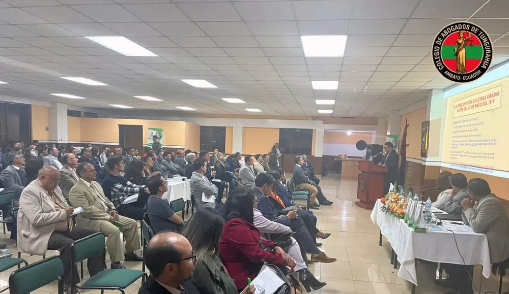 Auditorio lleno de abogados escuchando a un expositor en el podio, con una presentación proyectada sobre letras de cambio