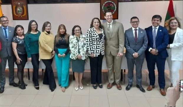 Grupo de ponentes, organizadores y asistentes posando en el auditorio del Colegio, con los emblemas institucionales al fondo